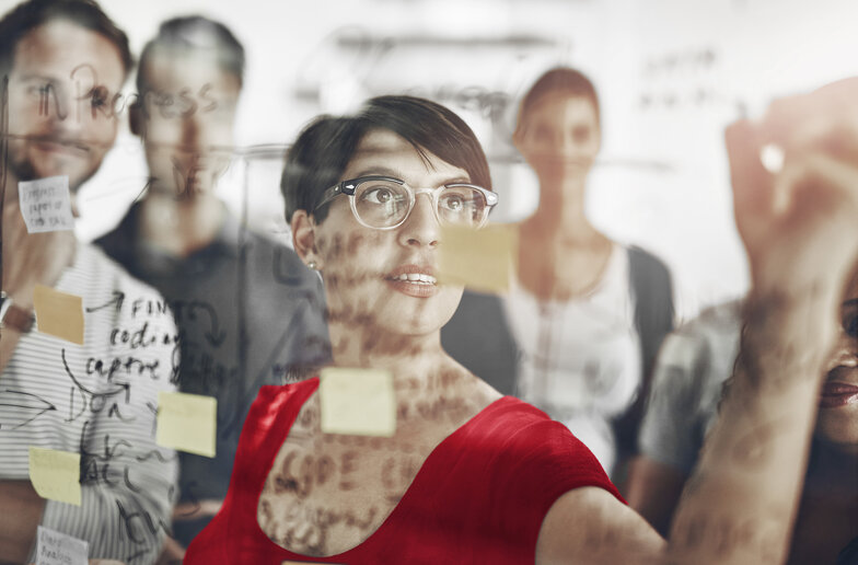 Karriere bei der Dussmann Group Mitarbeitende schreibt an Whiteboard