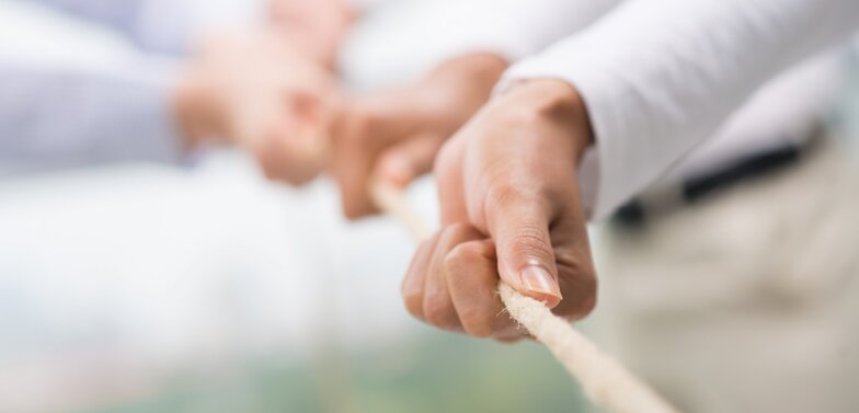 Dussmann Group's ESG strategy with a focus on governance Hands pulling together on a rope